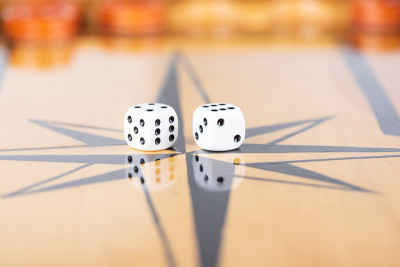 在一个木制的西洋双陆棋棋盘上的骰子和跳棋。