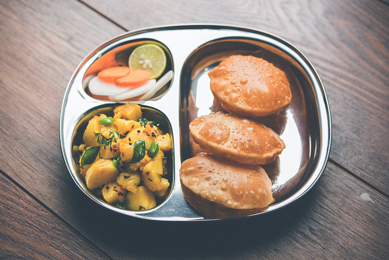 Masala Aloo Sabzi也叫孟买土豆，配上炸过的puri或Poori，放在铁板上，有选择的