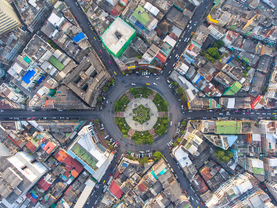 鸟瞰图，道路环岛，高速公路与汽车停车场在泰国的城市。美丽的街道，市中心，城市景观，顶视图。背景