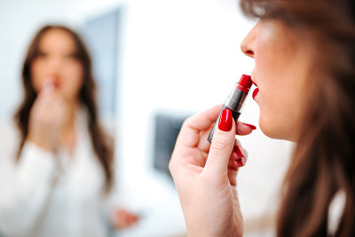 特写的女人抹红色的口红。