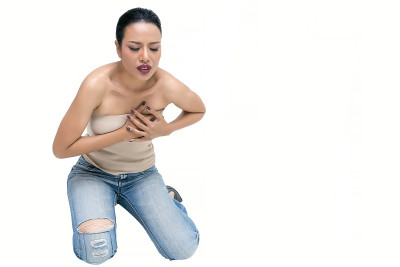 美丽的中年亚洲妇女的手压在她的乳房，感觉胸痛孤立在白色的背景