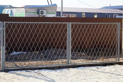 外面的灰铁金属网大门在雪地里