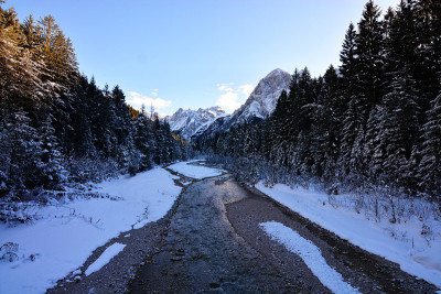 这条河缓缓地流过冰雪覆盖的冬季森林
