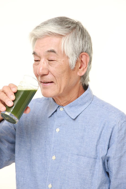 日本老男人和绿色蔬菜汁