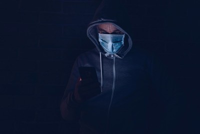 惊恐的男子在智能手机上阅读covid-19冠状病毒信息。
