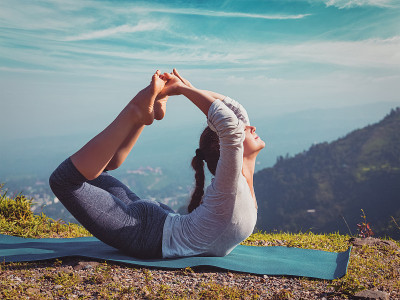 女子做阿斯汤加串联瑜伽体式Dhanurasana -弓体式