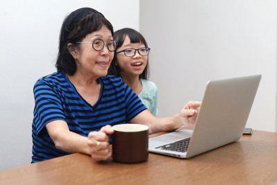 奶奶和孙女在家里打视频电话。