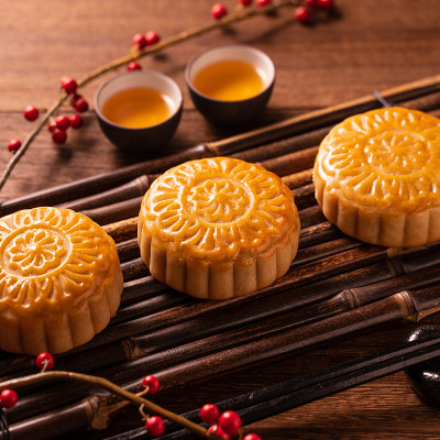 中国传统糕点月饼竹制托盘上的茶杯月饼木制背景中秋节。