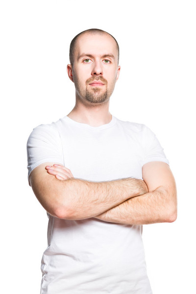 自信英俊的男子在明亮的t恤孤立在白色