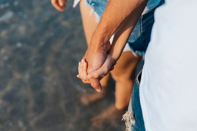 一对情侣在早晨的海滩上牵着手。一对新婚夫妇在浪漫的假期