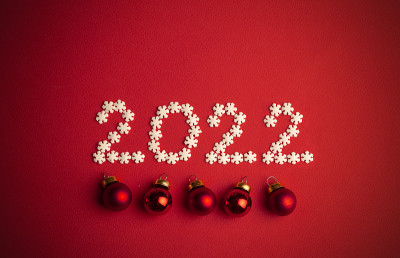 新2022年。创意数字写在白色雪花在红色的背景上设计。2022年新年概念