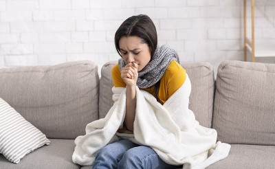 生病的年轻女士患有病毒，咳嗽到她的手在家里
