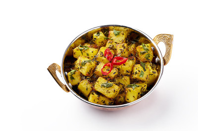 Aloo Methi在铜卡代，碗孤立在白色背景。Aloo Methi是用土豆、胡芦巴和香料做成的印度