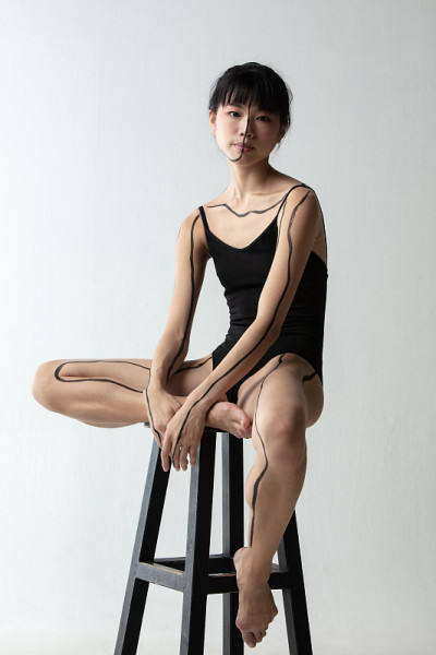 年轻可爱的日本芭蕾舞女演员坐在高椅子上，在浅灰色的工作室背景下思考孤立。美，线条艺术，内心世界概念。