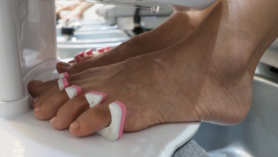 脚Spa。在水疗店的肥皂水机里，女人光脚按摩。女人的脚进入脚浴在热水手持式。在水疗沙龙用脚油按摩。放