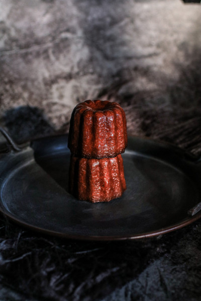 波尔多的Caneles de bordeaux在日出的黑暗背景下。法国甜饼Canele朗姆酒和香草味