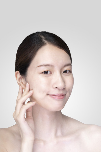 亚洲年轻女子触摸脸与放松的表情