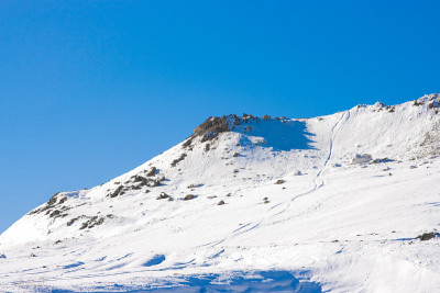 山。从积雪覆盖的山坡上高速下降的小路。