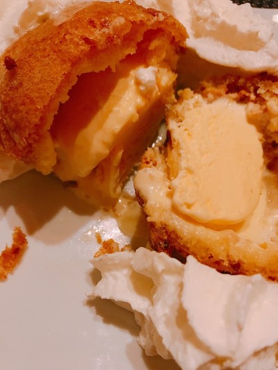 美味的餐厅甜点，一勺炸香草冰淇淋，上面淋上鲜奶油
