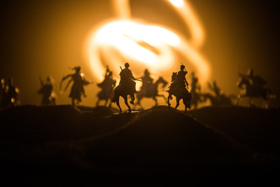 有骑兵和步兵的中世纪战斗场景。剪影的人物作为单独的对象，战斗的战士之间的黑暗色调的雾背景。夜景。