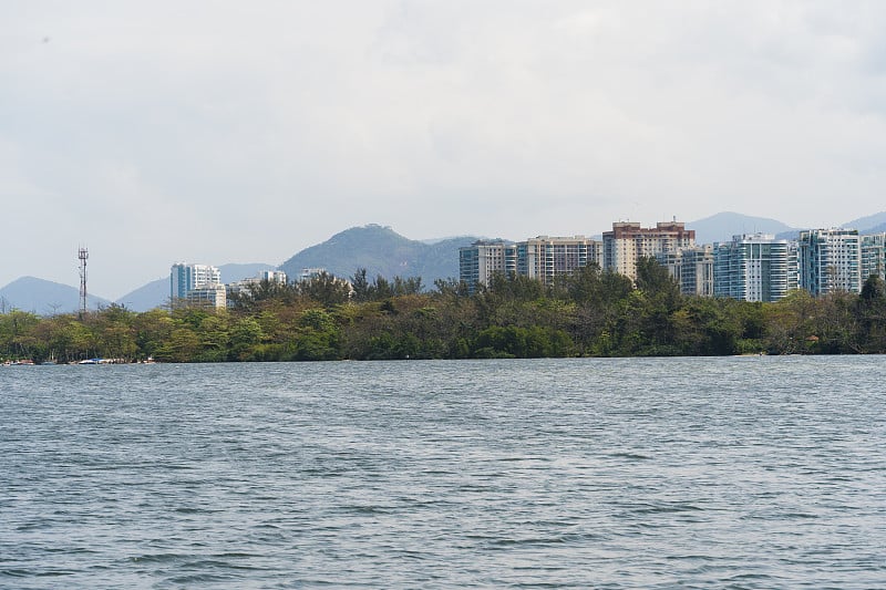 Marapendi泻湖的景观，背景是建筑和等待乘客的渡船。从泻湖上的另一艘船上看。位于里约热内卢的普