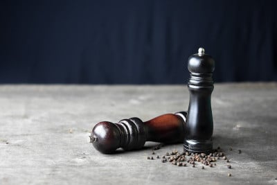 木桌上放胡椒磨。静物的概念。