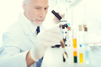 专注的成熟科学家伸出试管