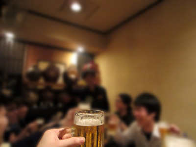 和同事在酒会上用啤酒罐敬酒