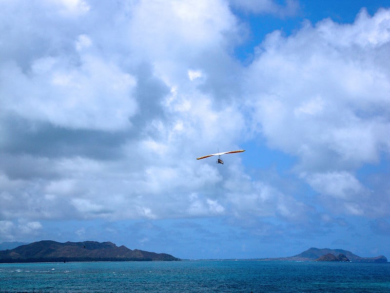 悬挂式滑翔机在威马纳洛湾上空翱翔