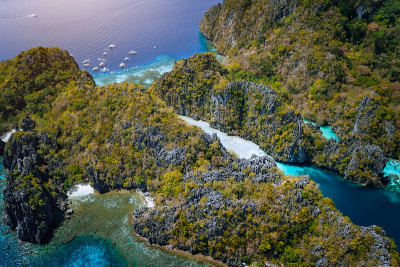 有石灰岩悬崖和蓝色海水的大泻湖入口的空中嗡嗡声。米尼洛克岛，菲律宾巴拉望El Nido海洋国家保护区