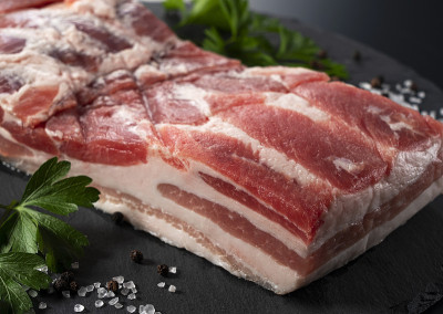 五花肉，黑胡椒，岩盐和意大利欧芹放在一个黑色的石盘上