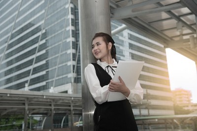 亚洲漂亮的女人在黑衣书写文件。