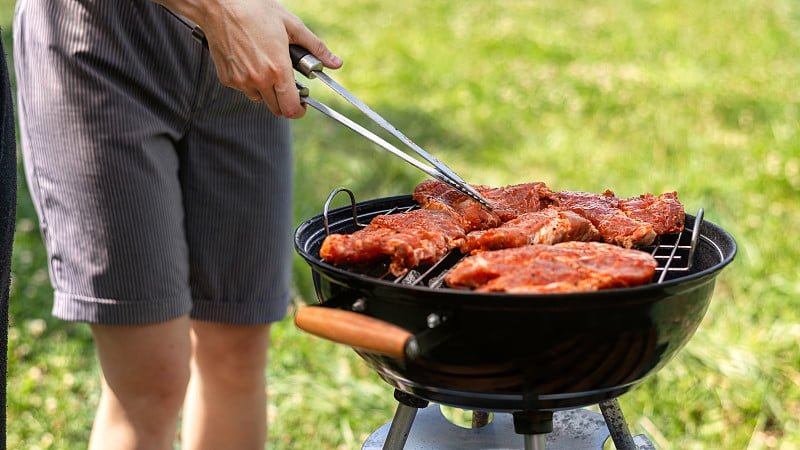 年轻人在烤架上煎肉