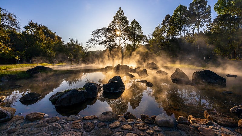 早晨阳光普照的泰国温泉和雾，温泉自然背景上的日出，泰国南邦采山国立公园的温泉。