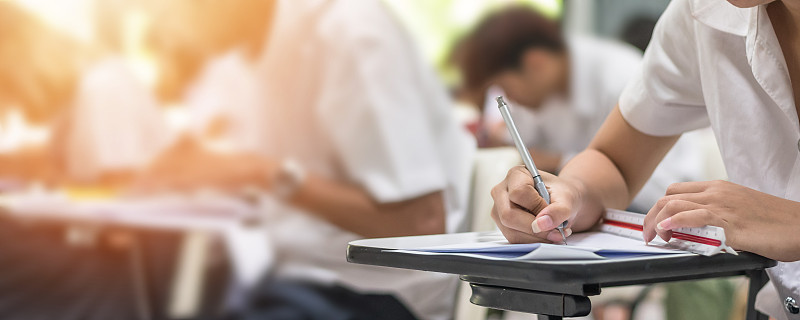 学校考试与学生在课堂上参加教育入学考试，在大学课堂上努力思考，写答案，教育和世界扫盲日的概念