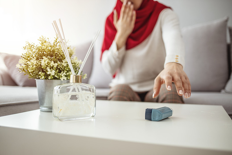 中年穆斯林妇女使用哮喘吸入器