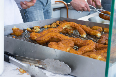 在农贸市场出售传统西班牙甜点油炸油条的小贩。街头食品。民族美食。真实的氛围。城市的生活方式。不健康食