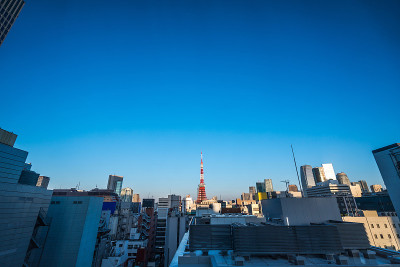 亚洲房地产和企业建设的商业理念-日本东京滨松町的蓝天和阳光下的城市全景鸟瞰图