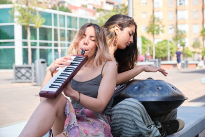 两个女人在街上吹手风琴和口琴。