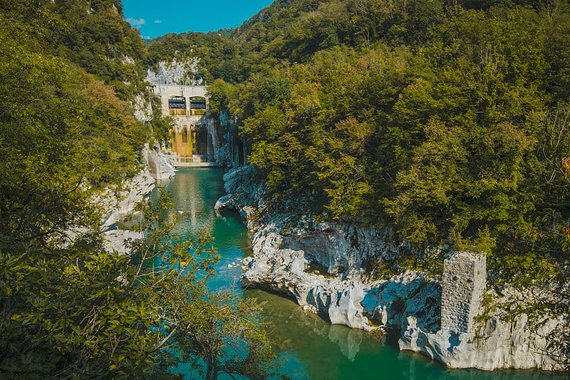 波德塞洛的小型水坝在索卡河接近大多数纳索西，水坝周围是郁郁葱葱的绿色和白色的白垩岩在夏天的一天。