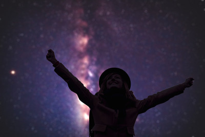 张开双臂享受星空的女人。