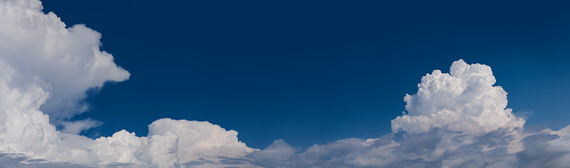巨大的白色积雨云在蓝天中升起的全景图像。Cloudscape,日本