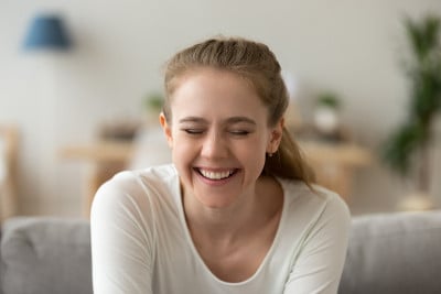 特写迷人的年轻女子笑着闭上眼睛