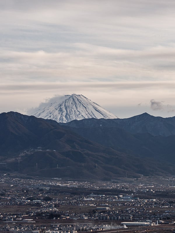 富士山的顶端高耸于周围的群山之上