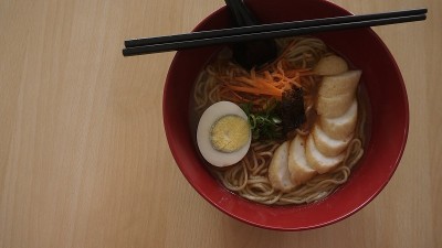 木桌上放着一碗带鸡蛋的辣拉面
