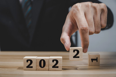 业务。商人手放木立方与数字变化从2021年到2022年，新年贺词，季度报告，商业计划，倒计时到202