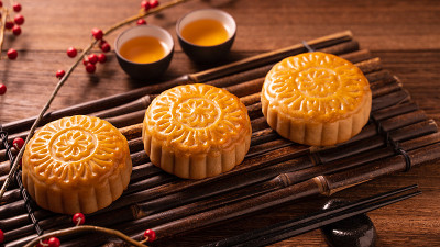 中国传统糕点月饼竹制托盘上的茶杯月饼木制背景中秋节。