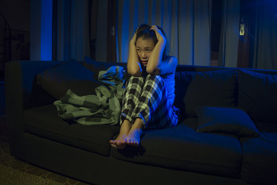 戏剧性的家庭生活方式肖像年轻美丽悲伤和沮丧的亚洲日本女人痛苦在客厅沙发沙发哭泣，不知所措和绝望的痛苦