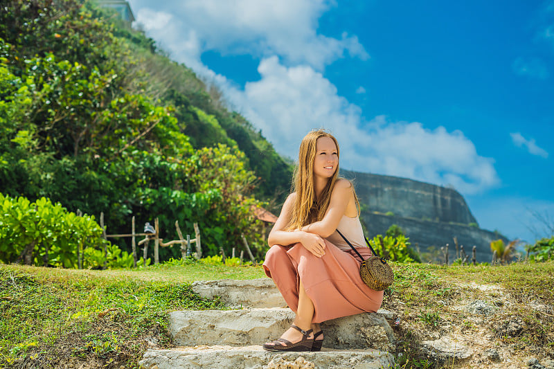 年轻女子旅行者在令人惊叹的美拉斯蒂海滩与绿松石水，印度尼西亚巴厘岛