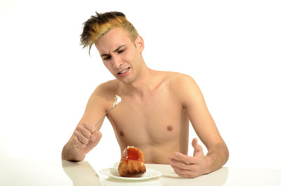 饥饿的年轻人厌恶变质的奶油蛋糕